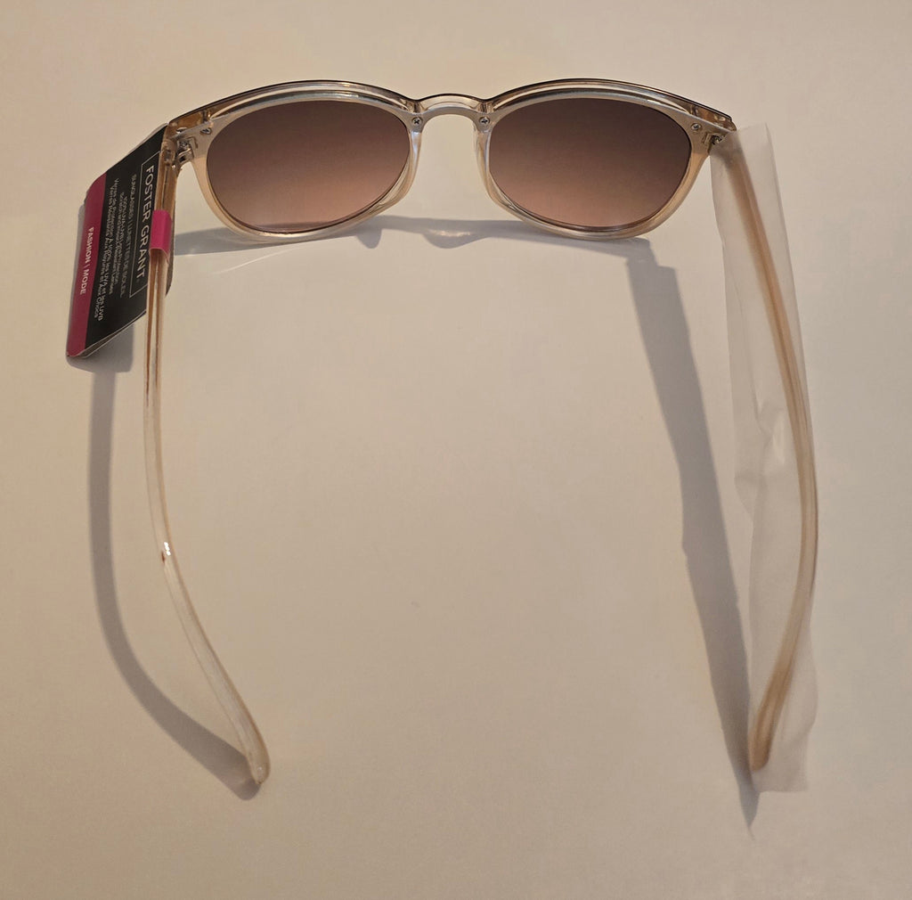 Sunglasses with a clear frame and brown gradient lenses on a beige background