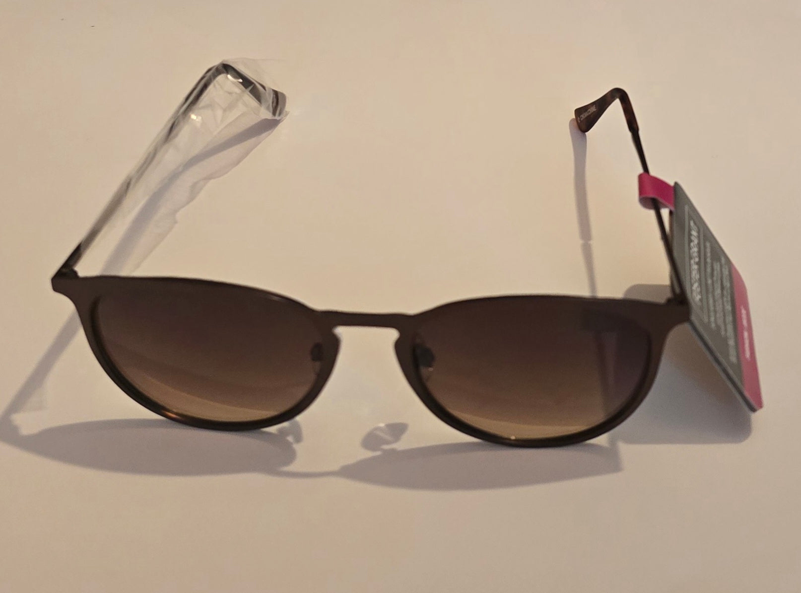 Sunglasses with a tag on a beige background